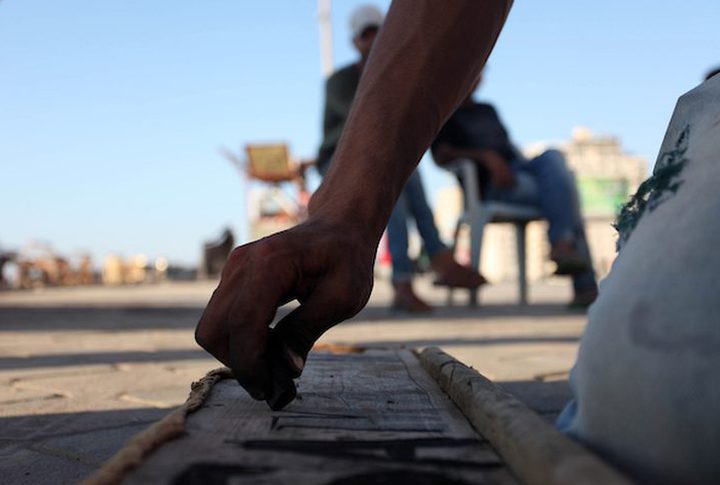 A young man from Gaza doing charcoal drawing on the sidewalk