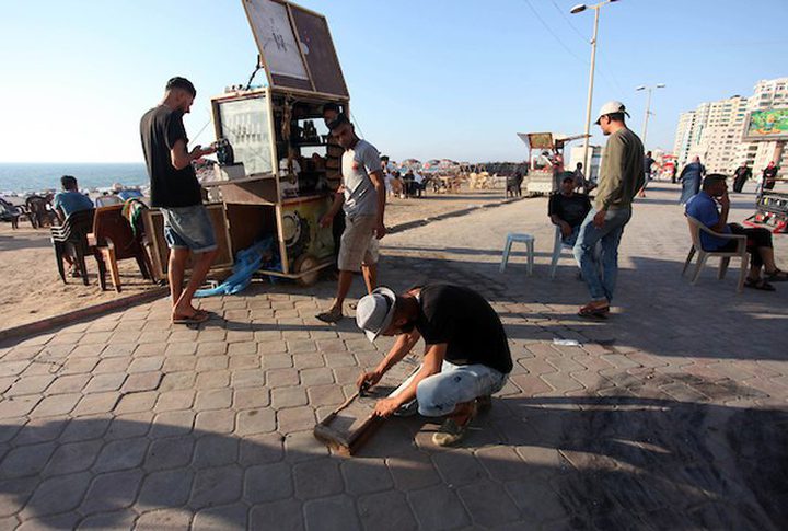 A young man from Gaza doing charcoal drawing on the sidewalk