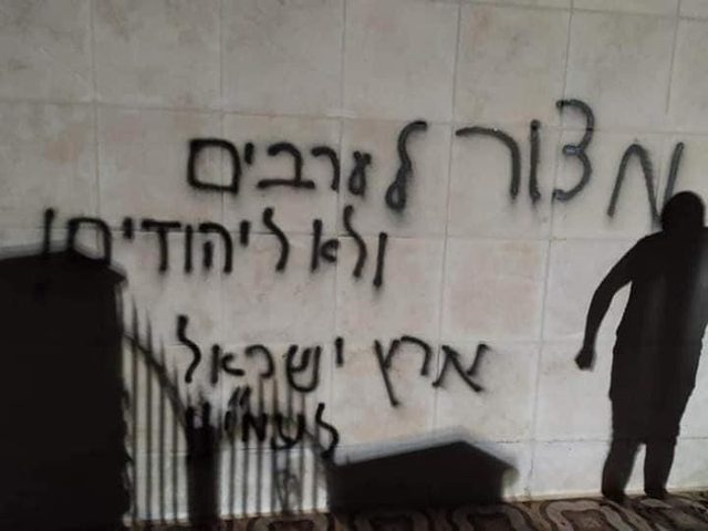 Terrorist settlers set fire to mosque in Al-Bireh spray racist graffiti on its walls